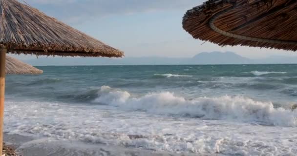 茅葺き屋根の傘を通して海の熱帯のビーチの海と美しい景色 透明なターコイズブルーの海を背景に空の砂浜 休日のコンセプト — ストック動画