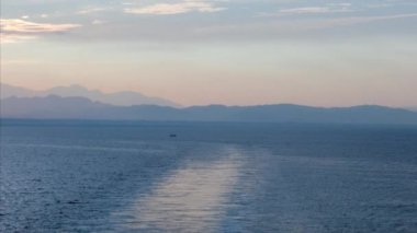  Gemi güvertesinden deniz dalgaları ve gökyüzünde sabah güneşinin doğuşunu seyret. Güneş 'in doğuşunun arka planına karşı küçük dalgalarla deniz yüzeyinin yavaş hareketi. Suyun üzerindeki güneş yolu. Altın ışık. Panorama