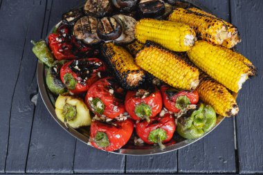 Ahşap zemin üzerinde ızgara sebzeler. Biber, mısır ve ızgarada pişmiş patlıcan. Mangal. Barbekü. Organik salata.