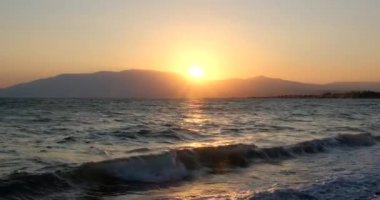 Tropik sahilde inanılmaz bir gün doğumu. Denizin üzerinde sarı güneş. Turuncu renk dalgaları. Doğa geçmişi. Güzel sakin bir sahne. - Günaydın. Güneş ışığı su yüzeyine yansıyor