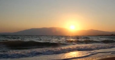 Tropik sahilde inanılmaz bir gün doğumu. Denizin üzerinde sarı güneş. Turuncu renk dalgaları. Doğa geçmişi. Güzel sakin bir sahne. - Günaydın. Güneş ışığı su yüzeyine yansıyor
