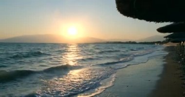 Tropik sahilde inanılmaz bir gün doğumu. Denizin üzerinde sarı güneş. Turuncu renk dalgaları. Doğa geçmişi. Güzel sakin bir sahne. - Günaydın. Güneş ışığı su yüzeyine yansıyor