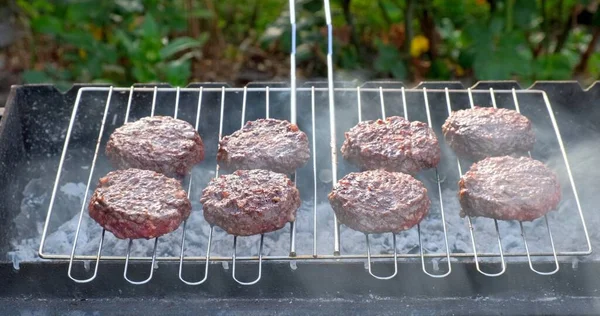 Beef and Pork Patty for Burger. Cooking Cutlets on Mangal. Grill Minced Meat. Chef Cooks burger in street outdoors. Summer Picnic in Nature. Tasty Meat Dish. Closeup