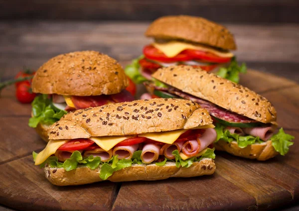 Ahşap Arka Planda Servis Edilen Pişmiş Burger Sandviçlerin Yakından Görünümü — Stok fotoğraf