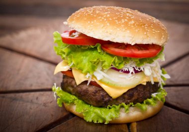 ahşap arka planda lezzetli burger görünümü yakın