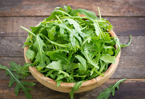 close up view of fresh arugula on wooden table
