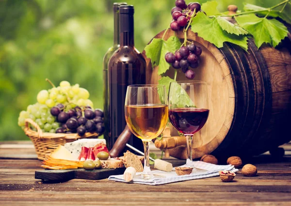 close up view of wine and snacks on wooden background