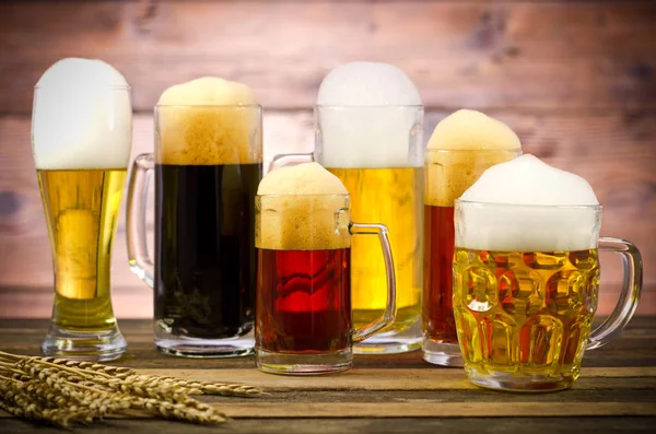 Vista Perto Vários Tipos Cerveja Canecas Superfície Madeira — Fotografia de Stock