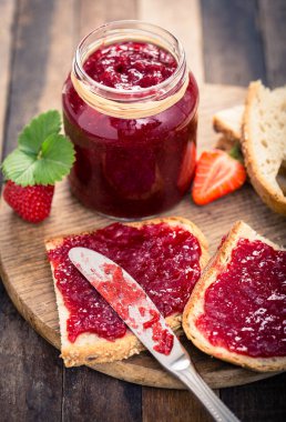 ahşap arka planda ev yapımı Çilek reçel ve tost yakından görünümü