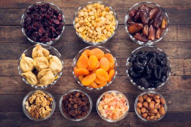 ahşap arka planda düzenlenmiş kurutulmuş meyve ve fındık