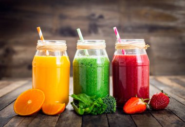 ahşap arka planda cam kavanozlarda sağlıklı taze içeceklerin görünümü yakın