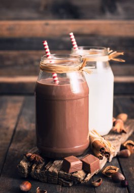 Görünümü kavanozların içinde süt ve çikolata meşrubatının ahşap masa kapatmak