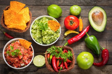 Baharatlı Meksika yemeği ve ahşap masanın üzerine düzenlenmiş soslar