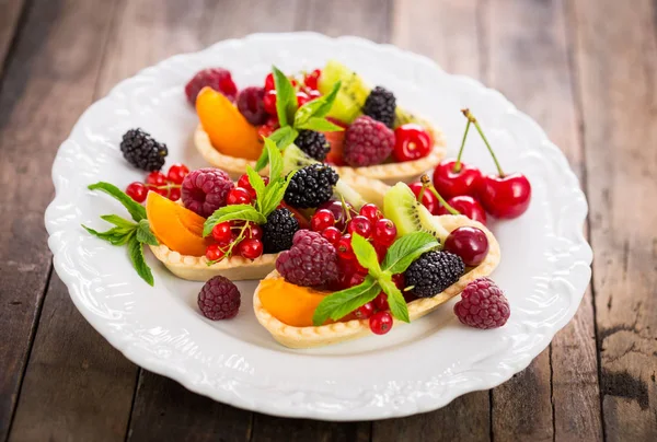 ahşap zemin üzerinde taze çilek ve meyveler ile Tartlets görünümü yakın