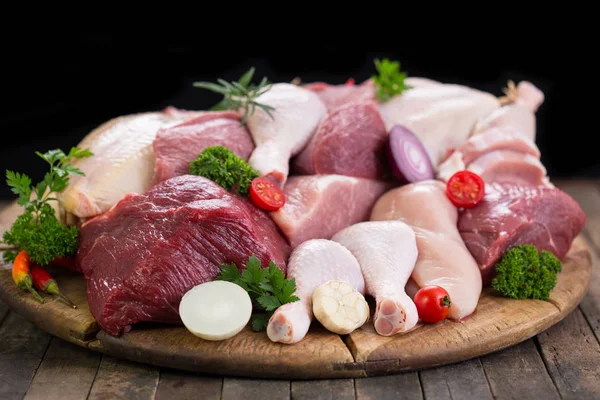 ahşap arka plan üzerinde sebze ile çeşitli çiğ et görünümü kadar kapatın