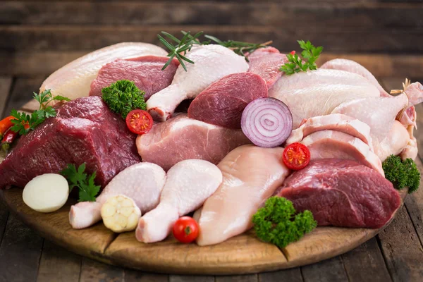 ahşap arka plan üzerinde sebze ile çeşitli çiğ et görünümü kadar kapatın