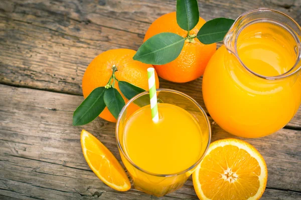 ahşap masa üzerinde cam saman ile sağlıklı portakal suyu Üstten Görünüm