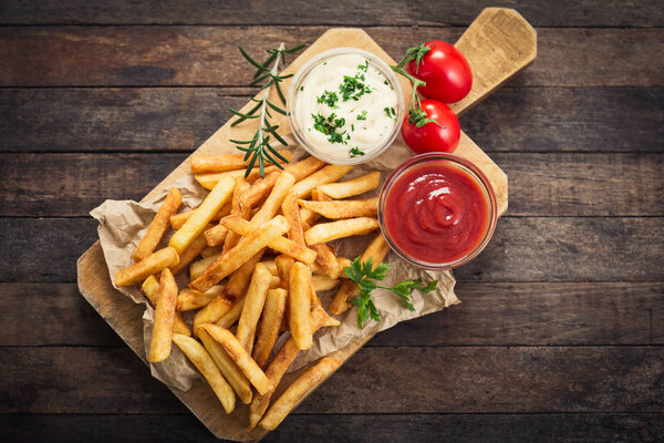 french fries and sauces arranged on wooden table