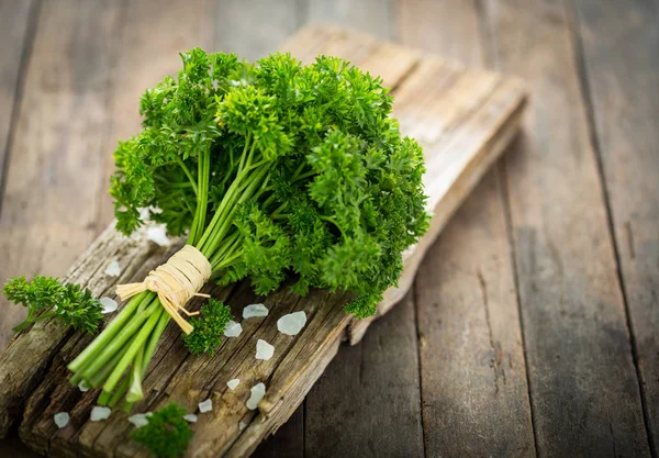 close up view of fresh parsley on wooden backdrop