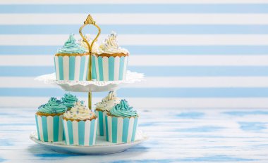 mavi ve beyaz zemin üzerine krema ile cupcakes görünümü kadar kapatın