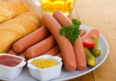 tabakta servis edilen sosis, ekmek ve sosların yakından görünümü