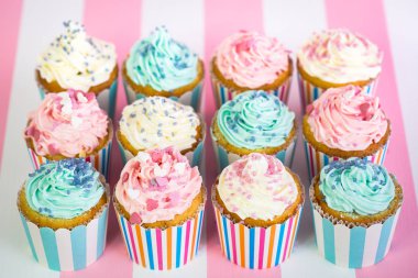 pembe ve beyaz zemin üzerine krema ile tatlı cupcakes görünümü kadar kapatın