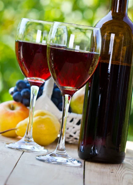 木製のテーブルの上に赤ワインと果物のグラスのクローズアップビュー — ストック写真