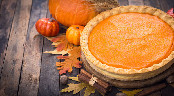 close up view of homemade pumpkin pie on wooden background