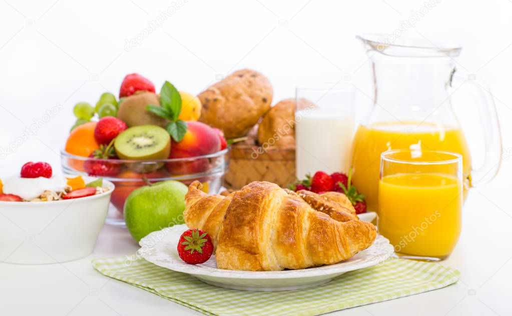 close up view of healthy breakfast with croissant, juice and fruits