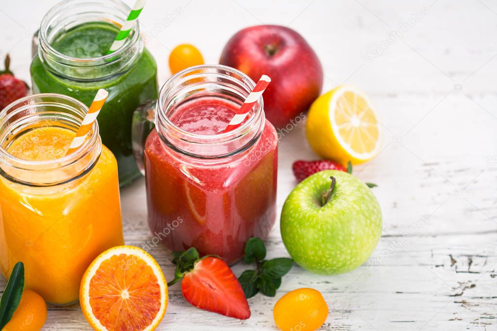 close up view of healthy drinks in glass jars on wooden background
