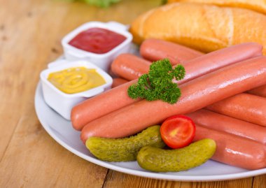 tabakta servis edilen sosis, ekmek ve sosların yakından görünümü