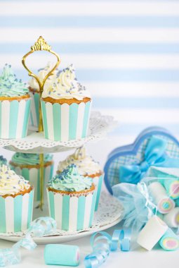 mavi ve beyaz zemin üzerine krema ile cupcakes görünümü kadar kapatın