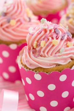 pembe ve beyaz zemin üzerine krema ile tatlı cupcakes görünümü kadar kapatın