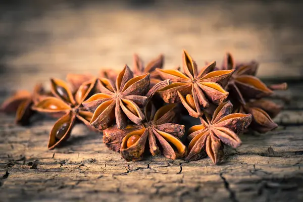 close up view of anise stars on wooden surface