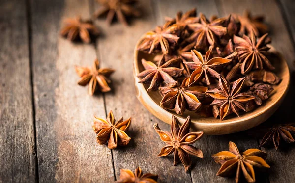 close up view of anise stars on wooden surface