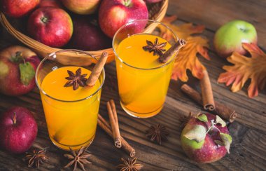 ahşap masa üzerinde bardak elma suyu ile tarçın ve anason yıldız görünümü kadar kapatın