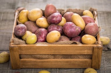 ahşap masa üzerinde ham patates kutusunda görünümü kadar kapatın