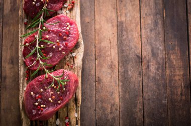 ahşap masa üzerinde baharatlar ile çiğ et