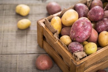 ahşap masa üzerinde ham patates kutusunda görünümü kadar kapatın