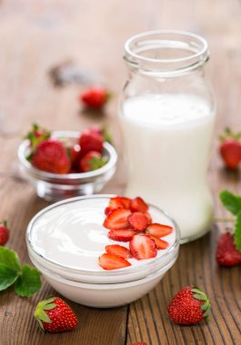 ahşap masa üzerinde taze çilek ile ev yapımı yoğurt