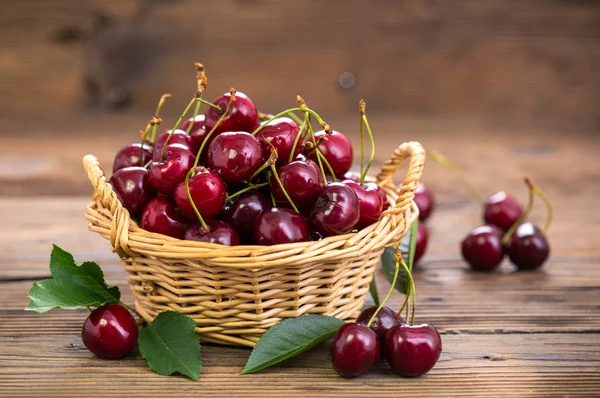 close up view of sweet cherries in basket on wooden table