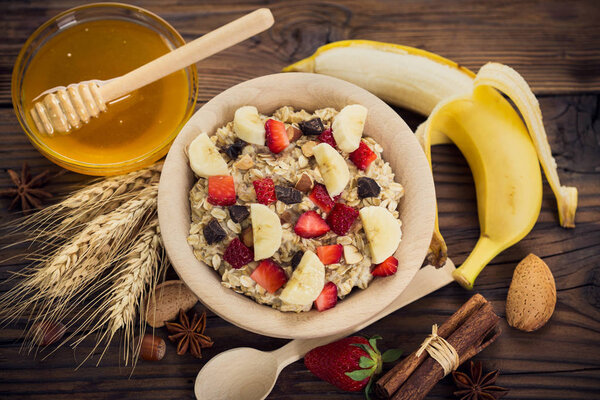 homemade healthy oatmeal with fresh berries on wooden backdrop