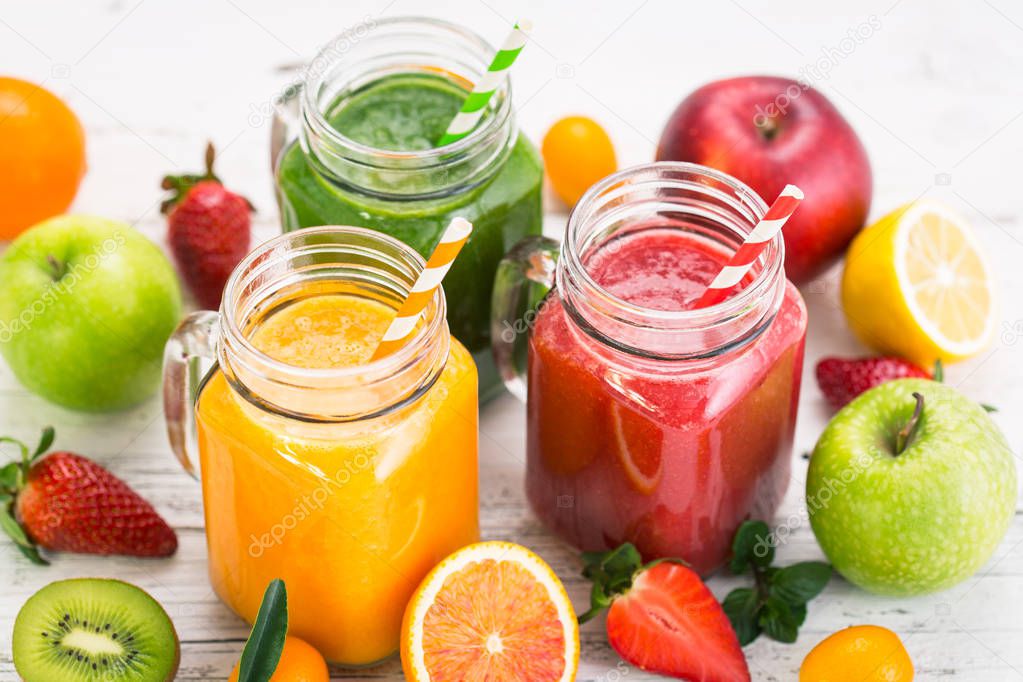 close up view of healthy fresh fruit drinks on wooden background