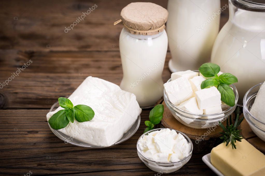 close up view of cheese and milk on wooden background