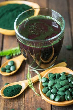 Sağlıklı spirulina bardakta su içer.