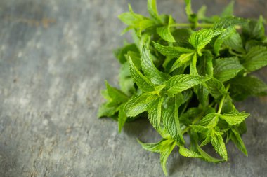 Kâsede taze organik nane yaprakları var.