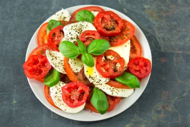 Taze mozarella, domates, fesleğen ve baharatlı caprese salatası.