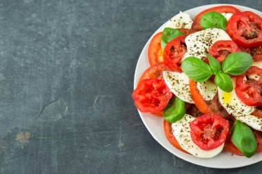 Taze mozarella, domates, fesleğen ve baharatlı caprese salatası.