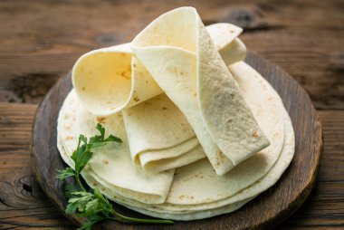 Ahşap masa arkasında tam buğday unu tortilla.