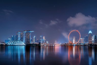 Marina Bay Area yansıması ile şehir merkezindeki Singapur şehir. Finans bölgesine ve gökdelen binalar gece.